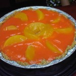 Cheesecake con salsa de naranja y melocotones